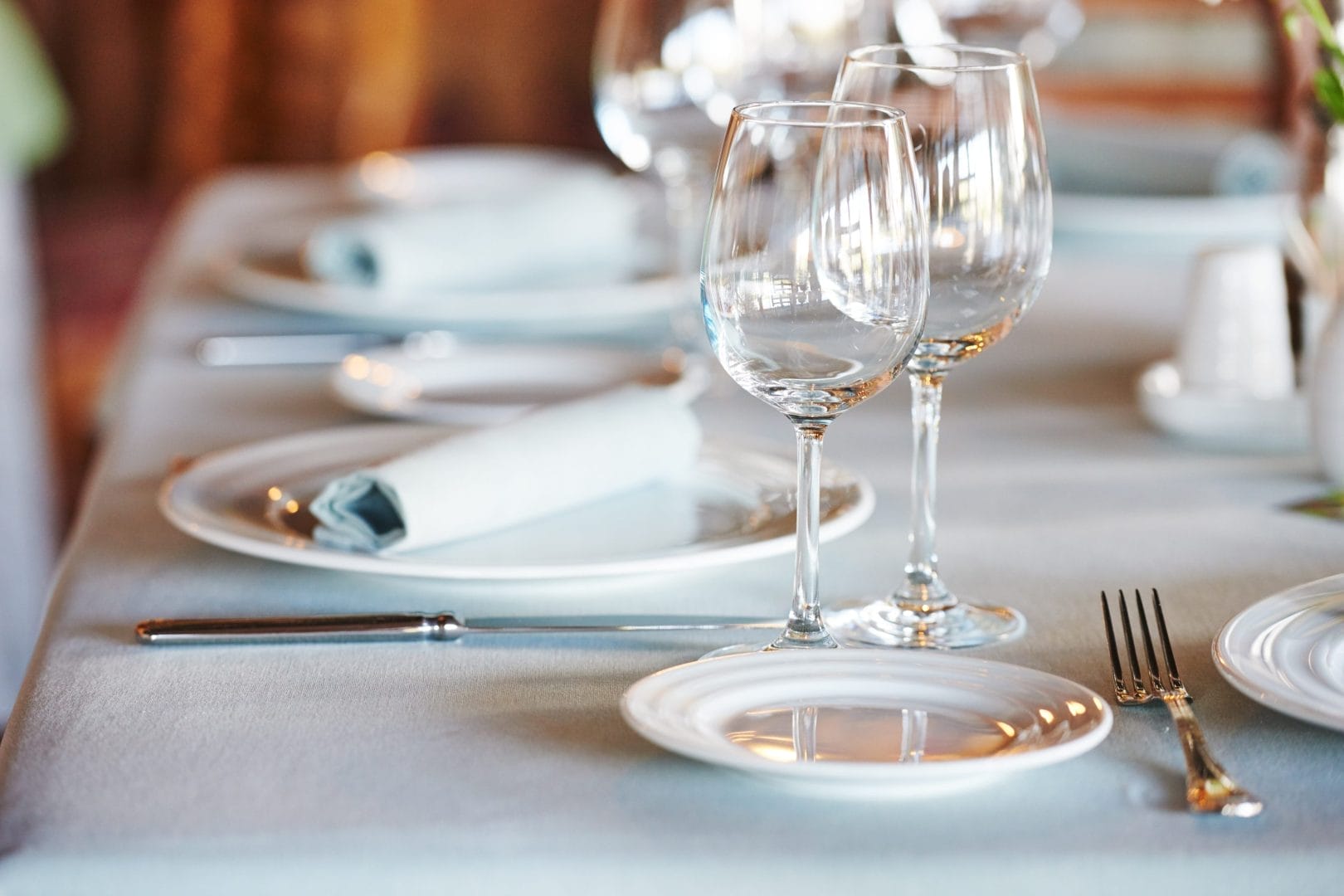 Tavolo elegantemente apparecchiato al ristorante privé dell’an hotel milano san donato, con mise en place raffinata e luce naturale